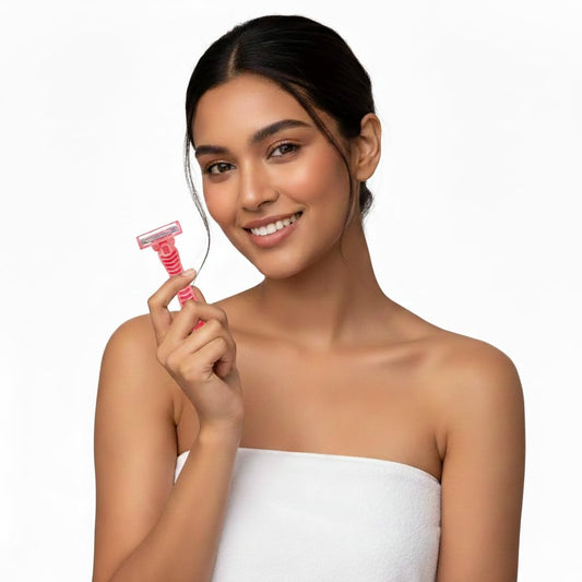Disposable 3-blade ladies razor with pink handle, held near shoulder