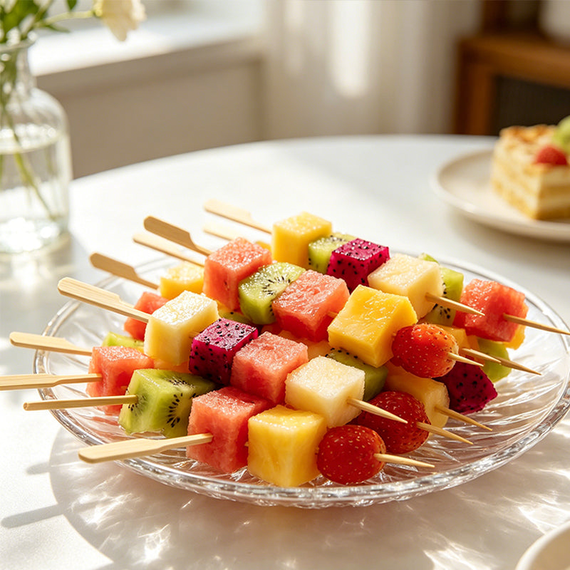 Fruit and vegetable skewers on wooden sticks arranged on a round serving dish