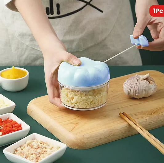 Compact manual food chopper with clear bowl, light blue lid, and stainless dicing blade