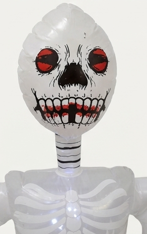 Close-up inflatable skull head with red eyes and open grin on white skeleton body