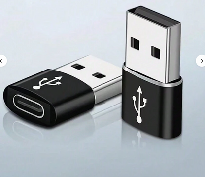 USB-A to Type-C adapter with black body and silver metal connectors, on reflective surface