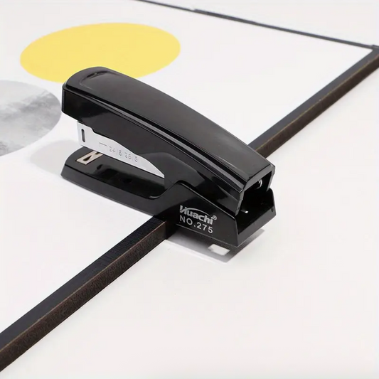 Black desktop stapler on paper, open mouth for heavy-duty stapling
