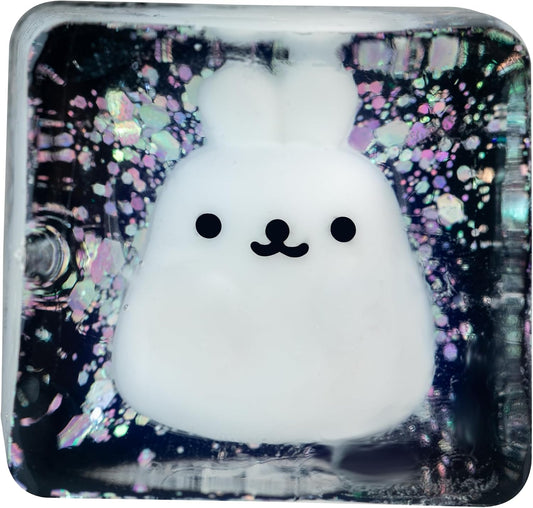 Squishy white bunny stress cube toy in glittery dark display box