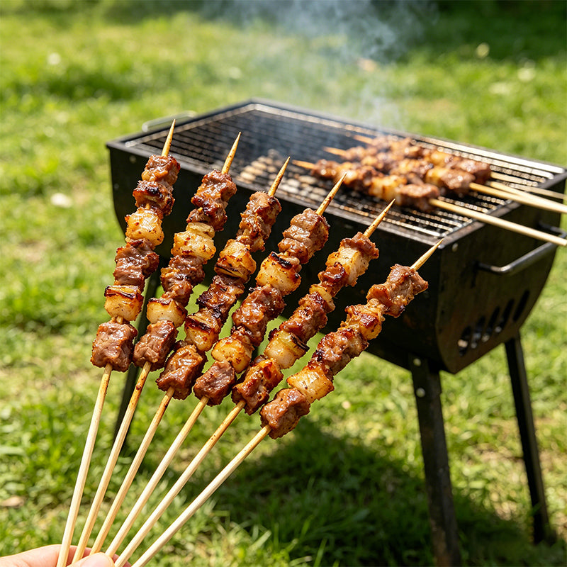 Row of grilled meat skewers on a barbecue grill with long wooden handles