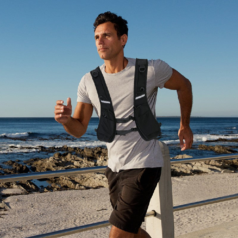 Black hydration vest worn with front storage pockets and reflective chest stripe