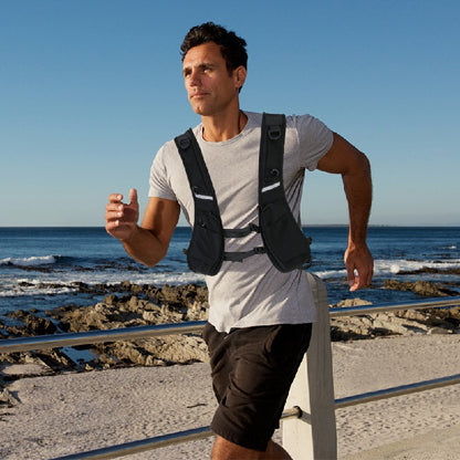Black hydration vest worn with front storage pockets and reflective chest stripe