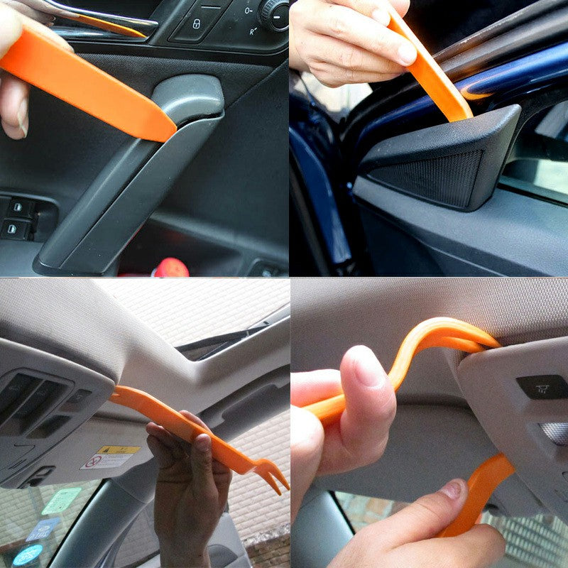 Orange car trim pry tools being used to lift door panel clips and edges