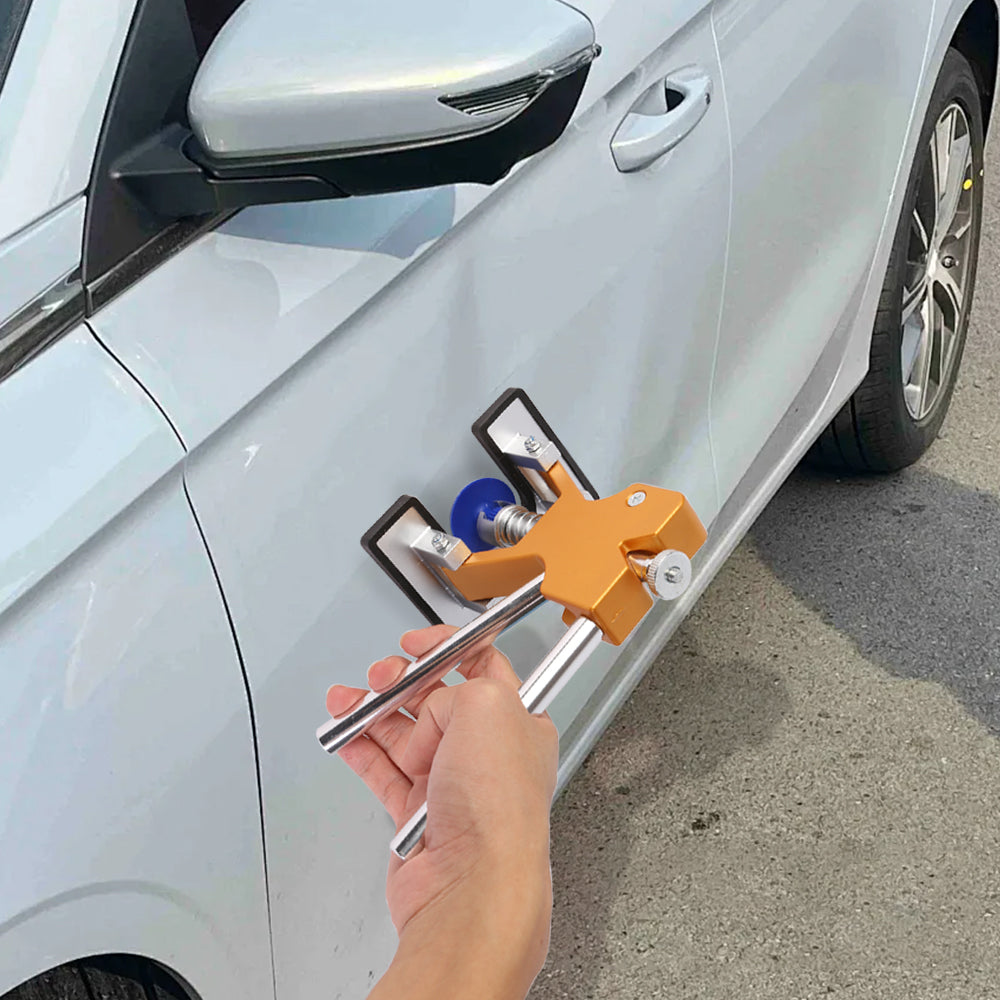 Car dent repair puller used on white car door panel by hand