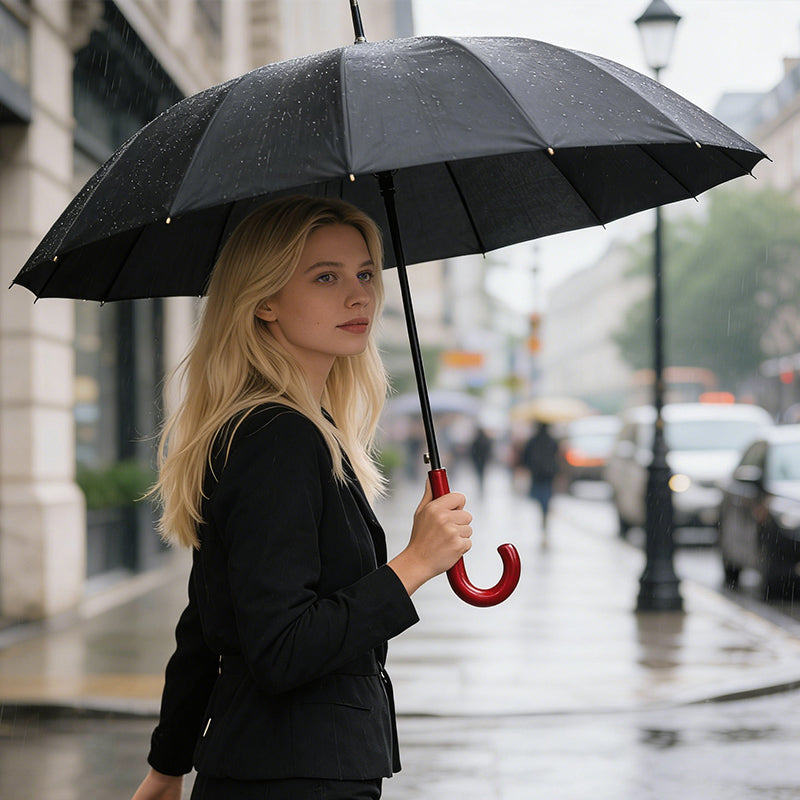 Windproof umbrella open, black canopy with red curved hook handle in hand