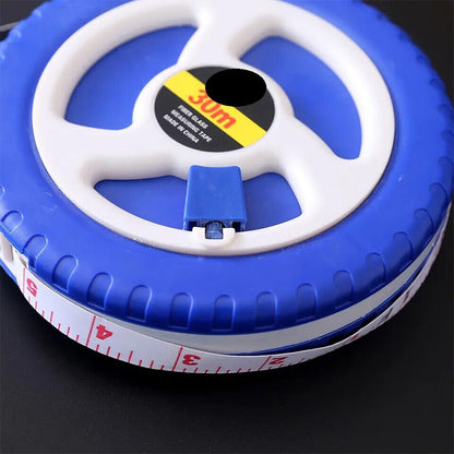 Blue and white fiberglass tape measure reel with partial measuring tape edge visible