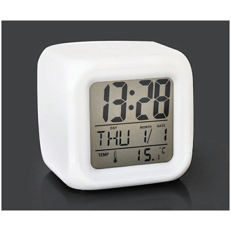 White cube digital alarm clock showing time, day/date, and temperature on display