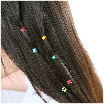 Colorful small hair elastics on dark hair with ponytail holders