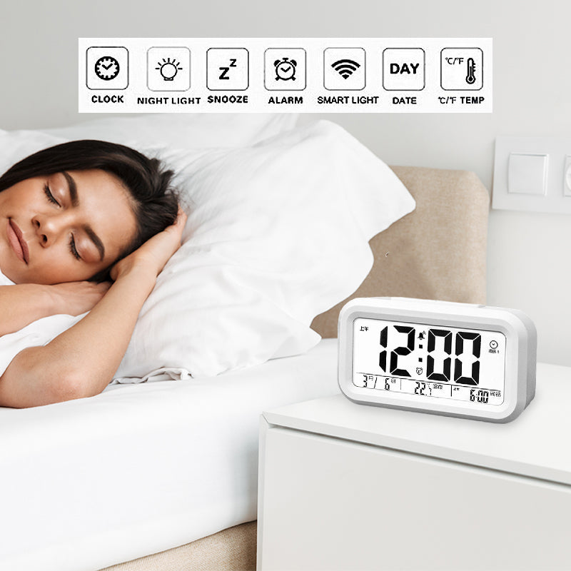 White digital LED alarm clock showing time, date, and temperature on the display