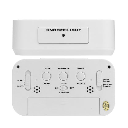 White digital alarm clock back panel with snooze/light button, dials, and sensor