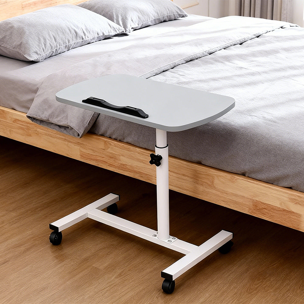 Adjustable overbed table tray, light grey top with black handle, on rolling base
