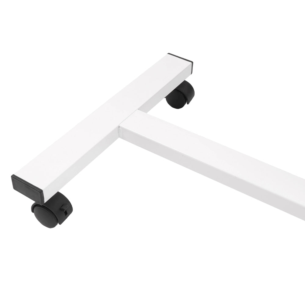 Overbed table tray on caster wheels, white frame with black handle pad, angled view
