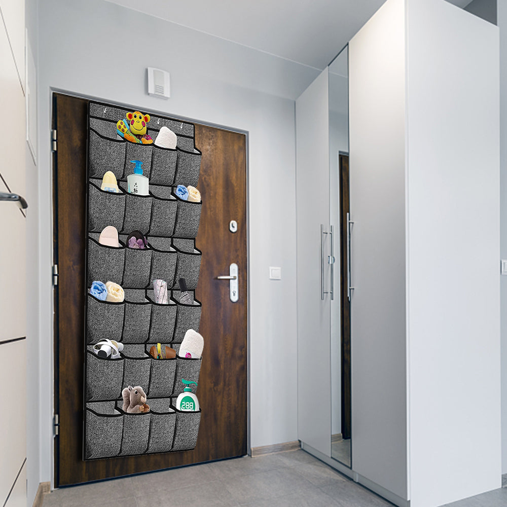 Hanging shoe organizer on a door with gray pockets holding several pairs of shoes