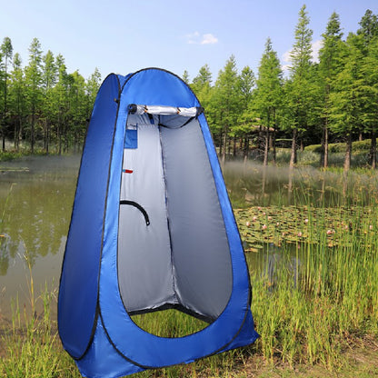 Blue pop-up shower changing tent with open front privacy panel outdoors near a pond