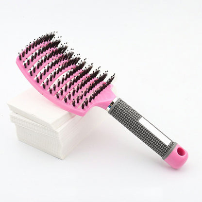 Pink curved paddle detangling brush with mixed black bristles and speckled handle