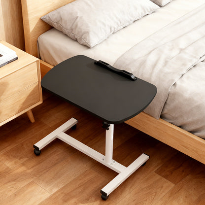 Adjustable overbed table with black tabletop and white stand on caster wheels