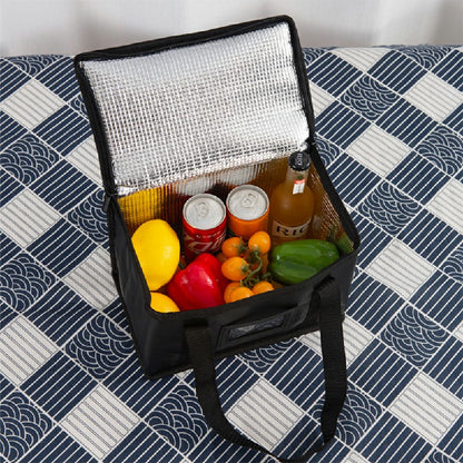 Black insulated bag open with silver lining and assorted groceries inside