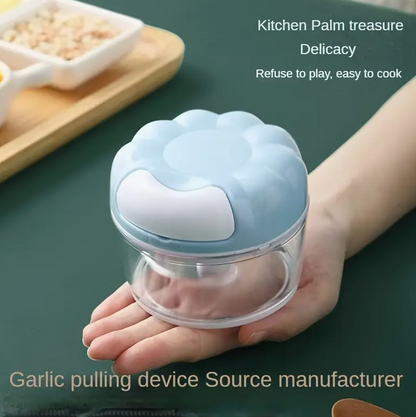 Manual food chopper with clear chamber and light blue lid, held in hands
