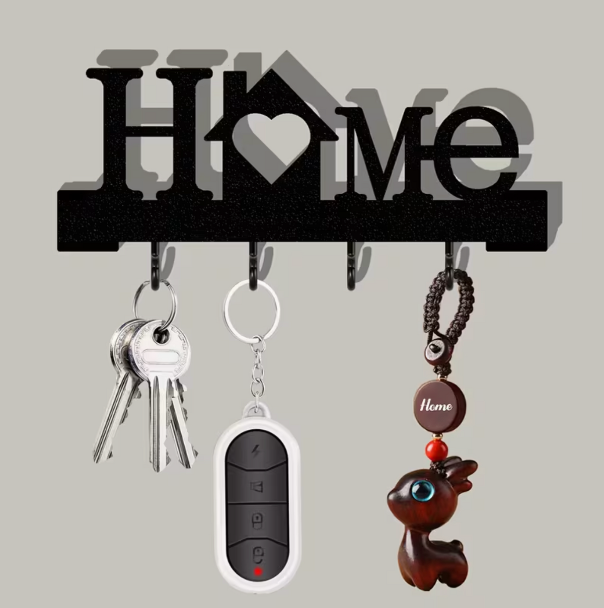 Black wall-mounted key organizer with heart motif and four hooks holding keys and fob