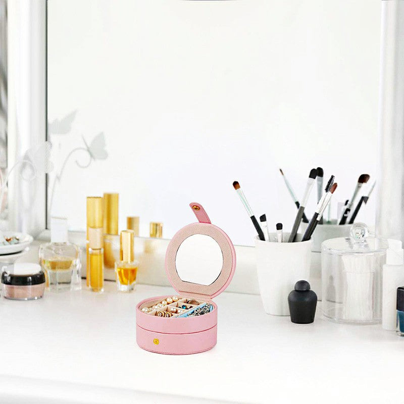 Pink round jewelry box case with small built-in mirror and open lid