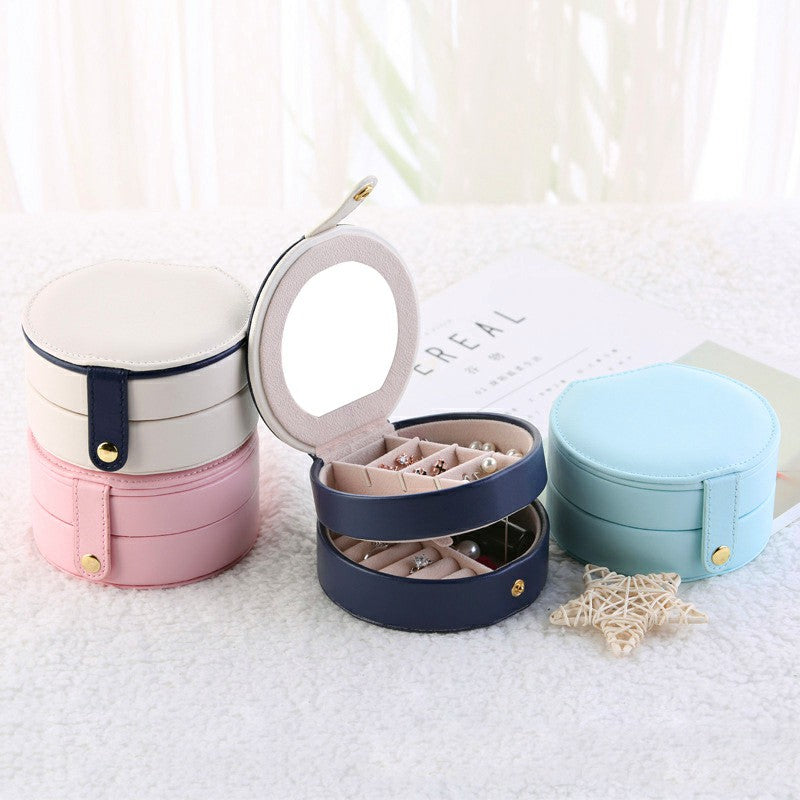Set of round jewelry boxes in pink, navy, and light blue with hinged lids