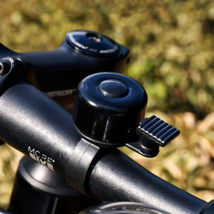 Blue and black bicycle handlebar bell with side button and clamp mount