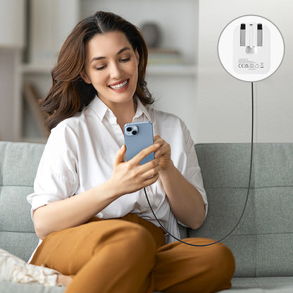 White foldable USB-C mains adapter plugged in charging a phone