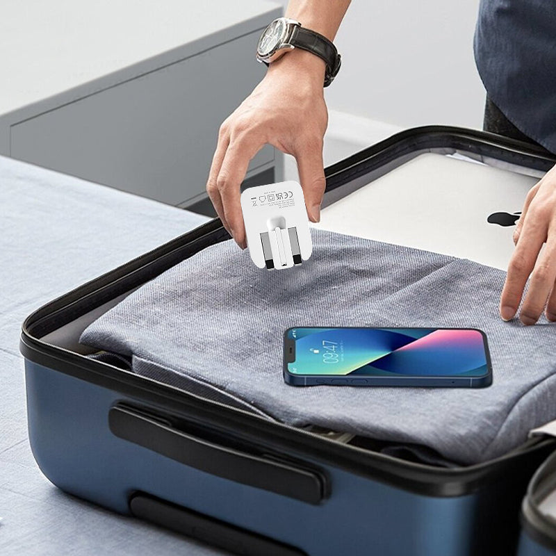 White foldable USB-C mains adapter held above a travel case with connected phone