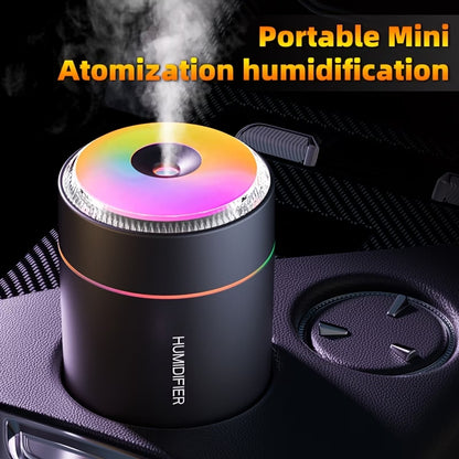 Mini humidifier with rainbow LED top, compact dark cylinder and mist vent