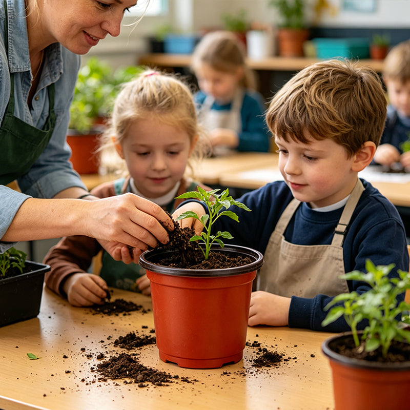 Red plastic plant pot on table as child plants a seedling