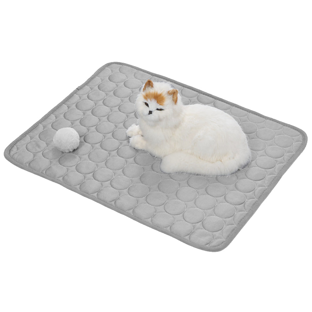 Grey self-cooling pet mat with raised honeycomb texture, cat resting on top.