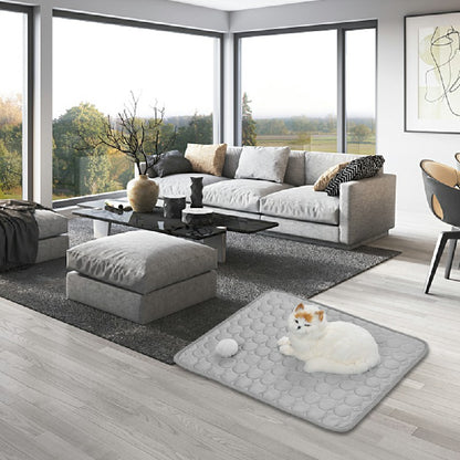 Self-cooling pet mat on living room floor, grey with textured surface, cat lying.