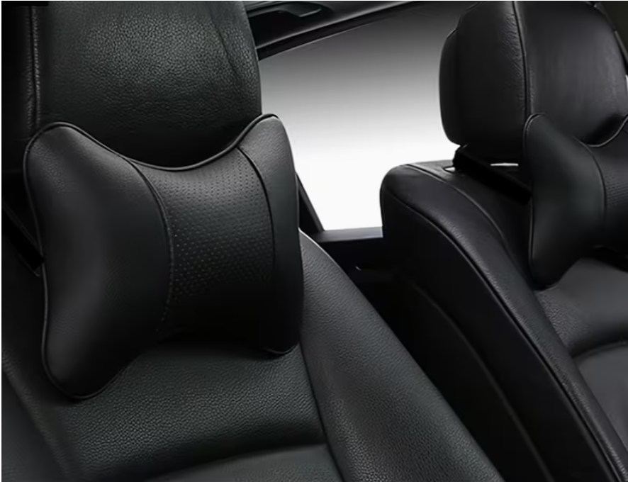 Black contoured car neck pillow with curved headrest support, installed on front seat