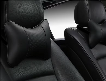 Black contoured car neck pillow with curved headrest support, installed on front seat