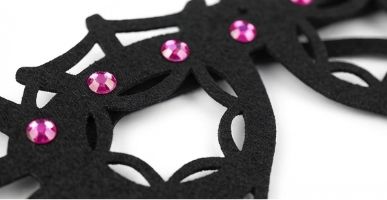 Close-up of black spider web glasses frame with pink jeweled studs