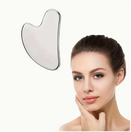 Stainless steel gua sha facial massager tool placed on cheek