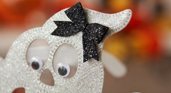 Close-up ghost novelty eyeglass frame with glitter white eyes and black bows
