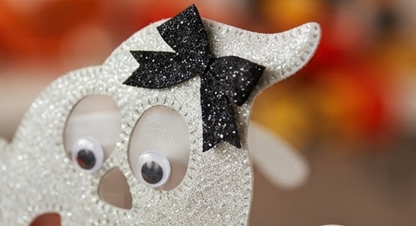Close-up ghost novelty eyeglass frame with glitter white eyes and black bows